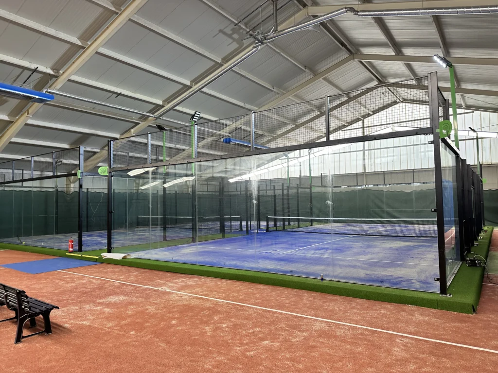 Indoor panoramische padelbaan met hoogwaardige, net vervangen kunstgrasmat van I-Padel, veilig en duurzaam geïnstalleerd in een ruime sporthal